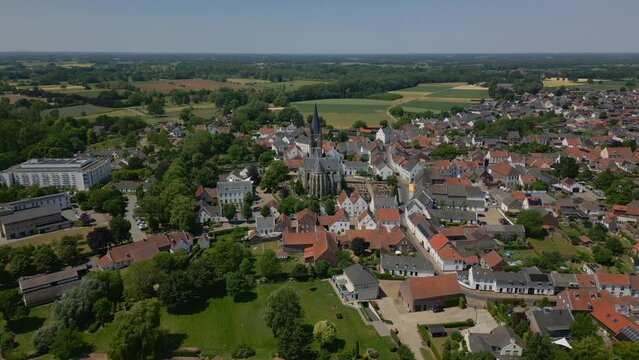 Wide angle drone shot over the historic commune of Maasgouw, Thorn in Limburg with beautiful view of the Limburg Abbes Church, houses and the flat landscape on a sunny day