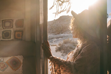 One dreamer travel woman admiring sunset light and landscape standing on the door of her tiny...