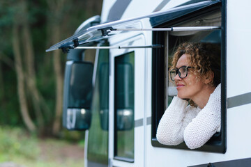Happy camper van tourist enjoying nature outside having relax at the vehicle window. Concept of...