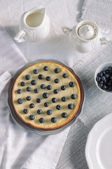 Homemade sugar free pie decorated with blueberries on breakfast table.