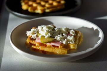 Waffle pizza with ham and pickled cucumbers and cheese. Hybrid food, piffle