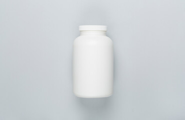 Plastic bottle with vitamins on color background, top view