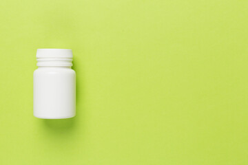 Plastic bottle with vitamins on color background, top view