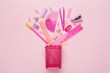 Pink holder with school stationery on color backgroung, top view

