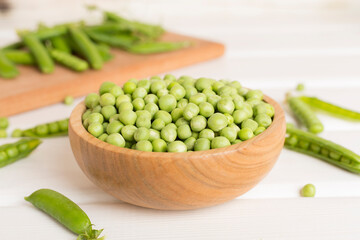Composition with fresh green peas on wooden table