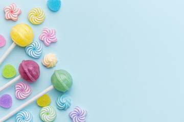 Sweet lollipops and candies on blue background
