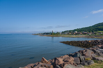 Fototapeta na wymiar The town of Largs set on the Firth of Clyde on the West Coast of Scotland. Looking from the marina into the town past the Pencil monument on a summers day