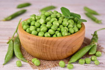 Young green peas in a wooden bowl.Close-up.
