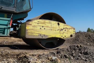 Soil Compactor, single drum road roller at the construction site of a highway.