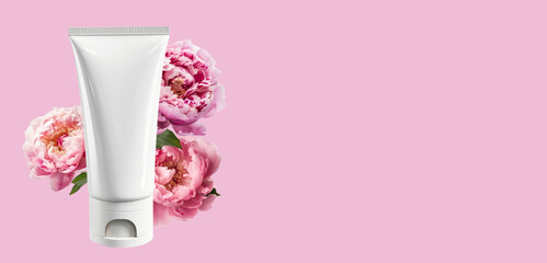 White empty tube mockup and pastel pink peonies on a pink background. The concept of natural organic cosmetics. Banner, Flat lay, top view, copy space.