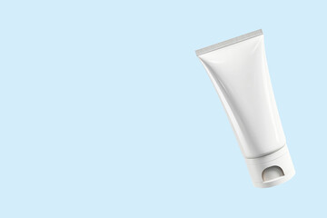 Mock-up of a white plastic tube of moisturizing cream on a light blue background. Flat plan, top view, copy space.