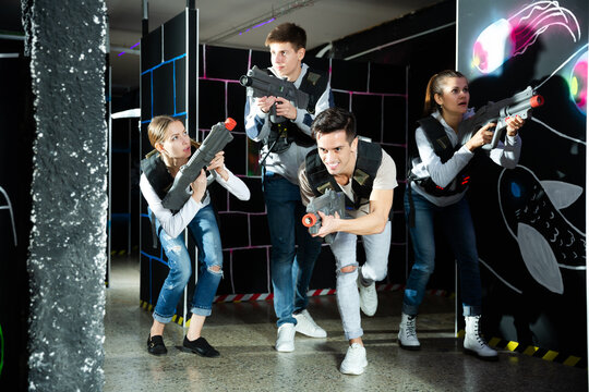 People in vests and with laser pistols playing emotionally laser. High quality photo