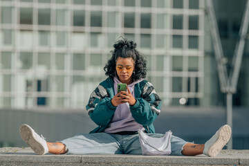 urban girl with mobile phone sitting on the floor