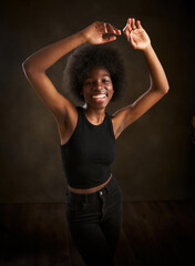 Fototapeta na wymiar young ethnic woman with afro hairstyle dancing with raised arms