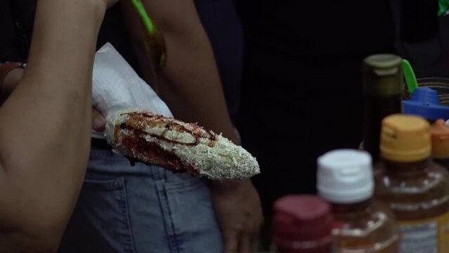 Latin worker preparing typical Mexican food for costumer in street stall. Slow motion