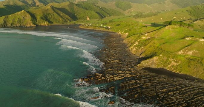 Golden sunshine lights up coastal landscape of New Zealand at Kiritehere beach