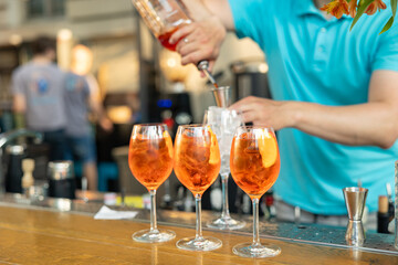 the bartender prepares a delicious Aperol spritz cocktails