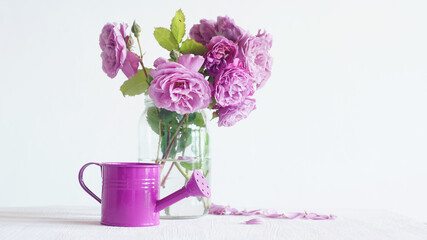 Bouquet of pink roses and a pink watering can