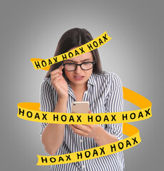 Information hygiene. Woman using mobile phone on grey background. Yellow tape with words Hoax...