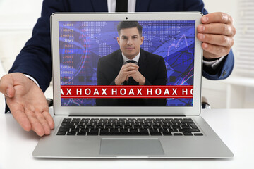 Exposing hoax. Businessman demonstrating laptop with blogger indoors, closeup
