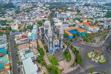 Aerial view of Thu Dau Mot cityscape at morning with church on hill in center. Urban development texture, transport infrastructure and green parks along Be River in Southeast region of Vietnam