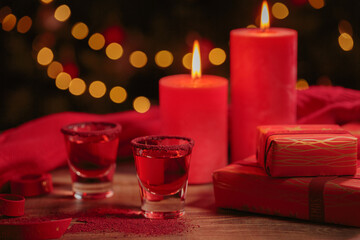 Cranberry vodka shot and Christmas decorations on wooden background. Winter holidays concept.