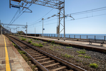 Fototapeta premium Devia Marina station tracks in Italy. No trains, no people, complete desolation and sadness. Beautiful open sea view