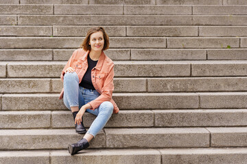 Young woman sitting on stairs in the city