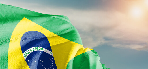 Brazil national flag cloth fabric waving on beautiful sky Background.