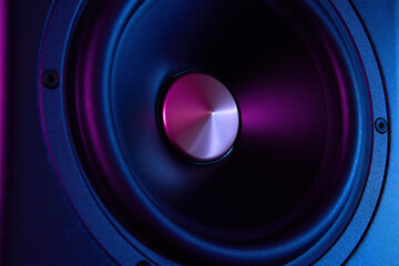 Multimedia acoustic sound speaker with neon lighting. Sound audio system on dark background.