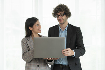 Obraz premium Portrait of young businessman and business woman standing, discussion, meeting together in office. Business people and office concept