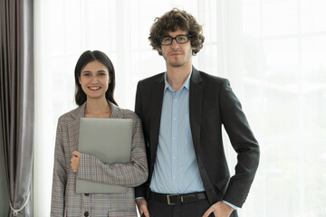 Portrait of young businessman and business woman standing with together in office. Business people...