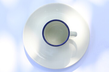 stainless cup on white saucer isolated on white background