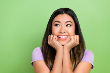 Photo of pretty vietnamese chinese young girl look empty space admire dressed stylish violet outfit isolated on green color background