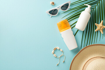 Dive into summer with these sun essentials. Top view of unlabeled sunblock lotion and SPF cream bottles, sunglasses, a sunhat, shell bijouterie, starfish, and a palm leaf on a pastel blue background