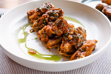 Chicken wings in sauce, a dish in a restaurant. A plate on a table.