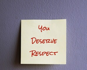 Yellow note with text written YOU DESERVE RESPECT stick on gray wall, concept of self remender to get or earn respect you deserve and never let people treat you like a doormat - obrazy, fototapety, plakaty