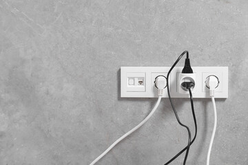 Many different electrical power plugs in sockets indoors, space for text