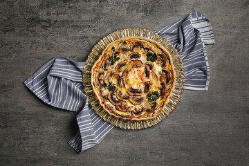 Delicious quiche with mushrooms on dark grey table, top view