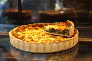 Delicious cheese quiche on counter in bakery shop, closeup