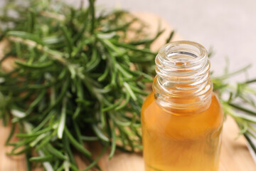 Bottle of rosemary oil on blurred background, closeup. Space for text