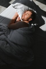Cute young man sleeping on bed