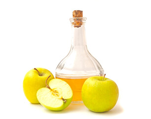 A decanter with apple cider vinegar, two and half apples isolated on white background.