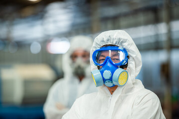 Male inspector team investigate danger chemical gas leak spill with safety face mask PPE suit in...