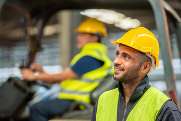 Portrait of forklift truck driver man smiling in old factory warehouse lifting pallet in storage shipping. forklift truck driver mail inside old forklift smiling to worker employee in warehouse store. © BESTIMAGE