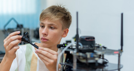 Boy male teen child concentrate enjoy Machine Learning Robot is Moving Under Control robot coding at technology stem class, stem education robot for digital automation artificial intelligence ai