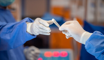 Team of surgery doctor in Operating Room hold hands scalpel surgical blade give to Surgeons During...