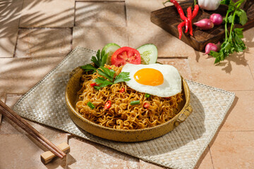 Fried noodles with sunny sides egg topping with tiles background