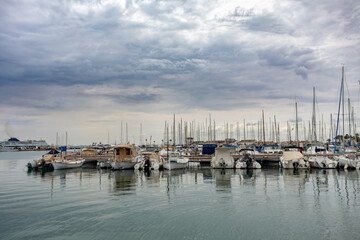 Fototapeta na wymiar Anchored ships in the port of Alcudia. Overcast morning weather. Balearic Islands, Mallorca, Spain.