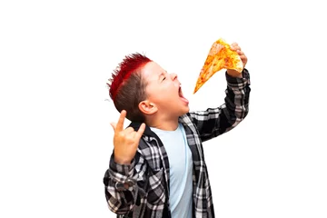 Foto op Canvas A cute stylish baby boy with a red mohawk on his head holds a big juicy piece of sausage pizza near his open mouth and shows a rock and roll hand sign. © volkonskaya